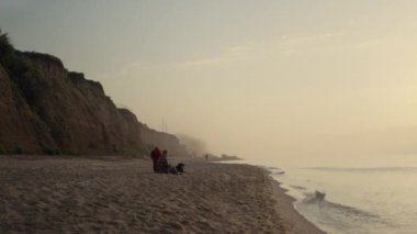 Romantik çift okyanusta günbatımının tadını çıkarıyor. Sahilde sevgili bir kadın ve erkek randevusu. Duygusal kız arkadaş, erkek arkadaşını omuzlarının üzerinden kucaklıyor. Deniz kıyısında oturan köpekli arkadaşlar. Şefkat kavramı