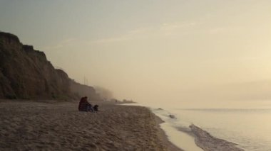 Güneşin doğuşunda deniz kenarında oturan romantik bir çift. Arkadan bakan güzel kadın, adamı omuzlarının üstünde kucaklıyor. Kayalık sahilde gün batımını seyreden genç aşıklar. Okyanus sahilinde köpekli hippiler. Aşk konsepti