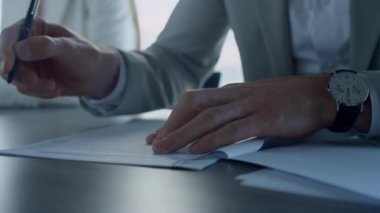 Ofiste el imzalı kağıtlar. Yakın çekim. Sigorta müşterisi takım elbise içinde anlaşmayı kontrol ediyor. Tanınmayan finans ortakları yöneticileri başarılı bir anlaşma yaptılar. İş adamları ortaklık kavramını karşılıyor