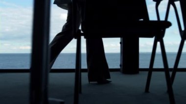 Panorama penceresindeki ofis odasında yürüyen siluet bacaklı. Müdür deniz manzaralı gazeteleri tutuyor. Bilinmeyen işçi, şirket görüşmesine takım elbiseyle gidiyor. Sekreter, sözleşme belgelerini müşteri toplantısına götür.