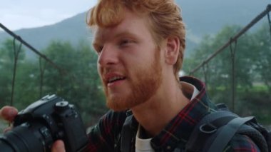 Gezgin turistler, köprü üzerinde doğanın fotoğraflarını çekiyorlar. Kızıl saçlı blogcunun portresi dışarıda çekiliyor. Rahatlamış milenyum adamı, dağ yürüyüşünde dijital kamera kullanarak fotoğraf çekiyor. Yaz tatili konsepti.