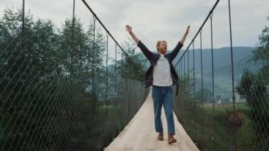 Kaygısız adam nehir köprüsünde doğayı keşfediyor. Heyecanlı yürüyüşçü aktif tatilde dışarı çıktı. Mutlu gezgin, turizm faaliyetlerinde özgürlüğün tadını çıkarıyor. Kızıl saçlı sırt çantalı gezgin. Mutluluk kavramı.