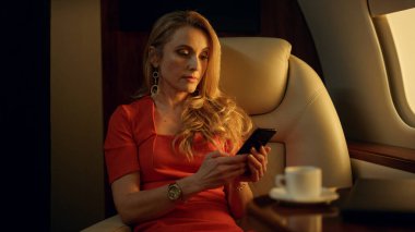 Şık bir iş kadını, gün ışığında akıllı telefondan mesaj atıyor. Zengin şirket yöneticisi özel lüks uçakla seyahat ediyor. Odaklanmış sarışın cep telefonu yazma mesajı. Gülümseyen kadın internette flört ediyor.