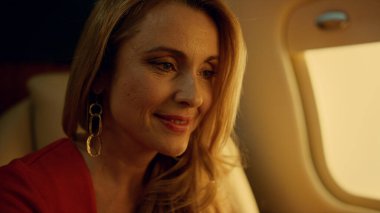 Altın güneş ışığı altında dinlenen dizüstü bilgisayarın kapanışı için mutlu Noeller. Lüks şirket uçağındaki işi bitiren memnun iş kadını. Kendine güvenen sarışın profesyonel birinci sınıf jette dinleniyor.