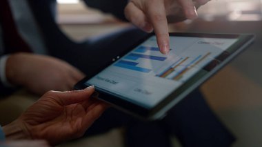 Tablet diyagramını kullanarak yakın plan yap. Bilinmeyen iş çifti uçuşta çalışıyor. Tanınmayan yöneticiler ellerinde kağıt tutarak şirket gezisi raporlarını analiz ediyorlar. Başarılı şirket sahipleri pazar verilerini kontrol ettiler