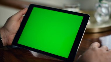 Kapalı krom anahtar tableti iş adamlarının elinde. Şirket bilgilerini analiz eden bir model cihazı var. Tanınmayan yönetici yeşil ekranda online webinar izlemeyi öğreniyor. İş teknolojisi kavramı