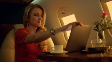 Altın güneş ışığında gevşemiş yönetici penceresi. İşten sonra özel bir jet gezisinde mutlu bir sarışın istirahati. Gülümseyen çekici iş kadını başarılı uçak anlaşmasından sonra rahatlama hayali kuruyor.. 