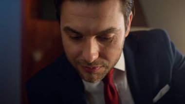 Takım elbise içinde çalışan yakın plan mutlu girişimci. Kendine güvenen iş adamı jeti. Gülümseyen yakışıklı bir adam bilinmeyen bir ortağın anlaşmasını tartışıyor. Zengin başarılı milyoner birinci sınıf yolculukta dinleniyor.