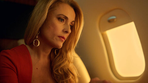 Финансовый директор работающий ноутбук на частном самолете крупным планом. Причудливая элегантная блондинка, проверяющая электронную почту, анализируя данные, получает хорошие новости о корпоративном путешествии. Привлекательная деловая женщина просматривает интернет на реактивном самолете.