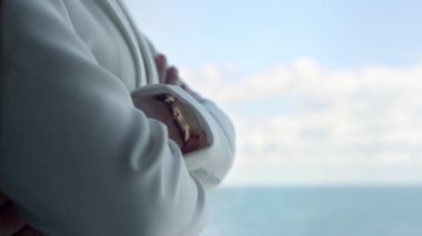 Unrecognizable director cross hands window. Rich businesswoman looking sea view closeup. Unknown rich boss enjoying ocean. Corporate journey luxury hotel overlooking water. Business lifestyle concept