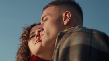 Portrait of romantic couple standing on beach. Happy woman and man posing at camera. Closeup boyfriend and girlfriend touching faces. Stylish hipsters wearing casual clothes. Relationship concept