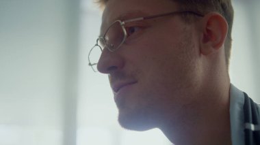 Yakışıklı bir doktorun portresi klinikteki bilinmeyen bir hastaya danışıyor. Gözlüklü genç hekimin kapalı mekanda ziyaretçilerle konuşmasını engelle. Modern hastanede çalışan tıp uzmanı..