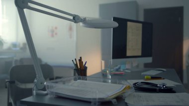 Doktor masasında çalışan boş bir tıbbi dolapta çalışan bilgisayar. Hastanedeki modern minimalist doktor işyeri manzarası. Tıbbi bilgilerle monitöre bağlandı. Sağlık hizmetleri kavramı.