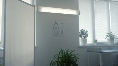 Standard eyesight test chart hanging white wall in doctor office closeup. Bigger smaller alphabet for eye examination in cabinet. Optometry poster for checking vision disease in ophthalmologist clinic