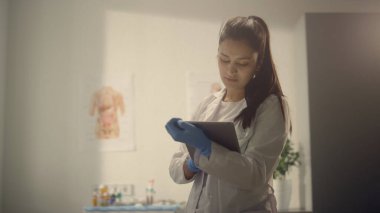 Doktor tablet kullanarak muayene sonuçlarını modern hastanede kontrol ediyor. Çok ırklı kadın hekim, sağlık kliniğinde yaşlı bir hastaya danışmanlık yapıyor. Genç terapist tıbbi reçeteyi açıklıyor