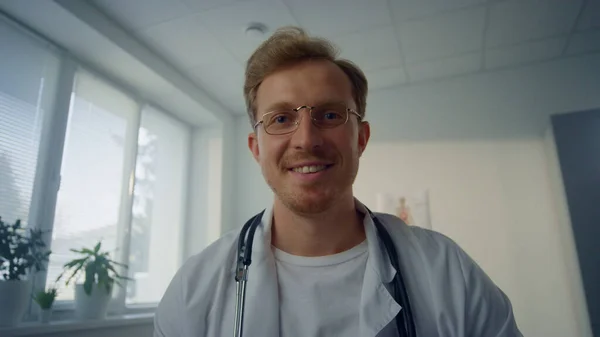 Pov video smiling physician completing patient examination in modern clinic. First person view. Portrait of handsome man doctor talking results medical checkup in hospital close up. Healthcare concept