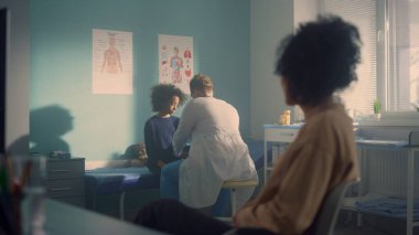 Afrikalı genç kız annesiyle birlikte doktor muayenehanesini ziyaret ediyor. Anne varlığında reşit olmayan çocuğu kontrol eden bir doktor. Modern hastanede tıbbi muayenede olan Afrikalı Amerikalı bir aile. Çocuk sağlığı kavramına önem vermek