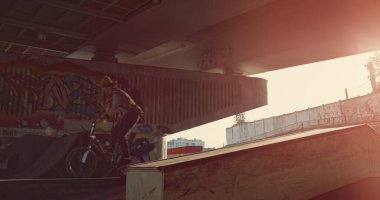 Modern kaykay parkında duvarlarında grafiti olan ekstrem adamlar. Bilinmeyen bmx binicisi ve patenci şehir alanında yarışıyor. Sportif aktif yaşam tarzı erkekler eylem zamanı kavramı. 