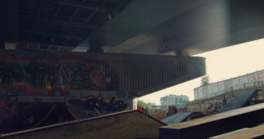 Duvarında sanatsal grafiti olan bir kaykay parkı. Gün batımında raylı ve rampalı boş bir kaykay parkı. Modern şehir alanının ayrıntıları. Şehir eğitim bölgesi. Aktif yaşam tarzı gençlik kültürü karantina tecrit kavramı. 