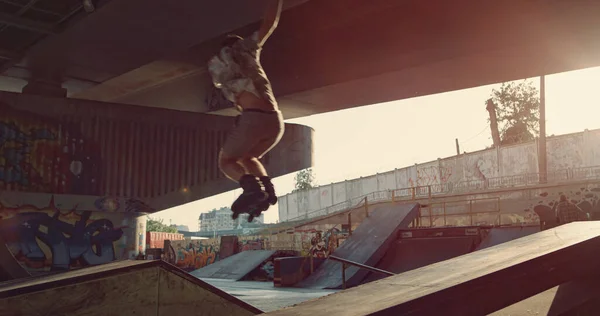 Sportowy Nastolatek Jazdy Wykonując Trick Skok Wrotkach Miejskim Skate Parku — Zdjęcie stockowe