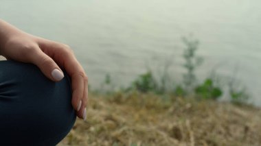 Bilinmeyen kadın ayakları deniz sahilinde poz veriyor. Genç kız, yaz sabahı yoga yaparken meditasyon yapıyor. Nazikçe diz çöküp spor kıyafetlerini giyerek yakın plan çekiyoruz. Stres yok.