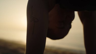 Siluet formda kız parlak gün batımı ışığında yoga yapıyor. Deniz kıyısındaki yaz akşamında Marjariasana 'da ayakta duran zayıf sporcu kadın. Doğada kedi-inek pozu veren esnek bir kadın. Dışarıda sağlıklı egzersiz..