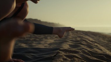 Yogi kızı dışarıda el ele dururken vinç pozisyonu alıştırması yapıyor. Sporcu sporcu, doğa yaz gününde jimnastik yapıyor. Kum kıyısında bakasana eğiten güçlü bir kadın. Sağlık yaşam tarzı..