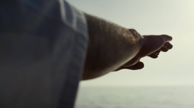 Sporcu elleri, deniz kıyısında judo eğitimi için el sallıyor. Kapatın. Gün batımında ayakta duran kumsalda karate tekniklerini bilen dövmeli bir adam. Dışarıda askeri tatbikat yapan tanınmamış bir sporcu..