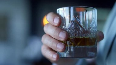 Elleri viski bardağını yakından tutuyor. Otel odasında dinlenen tanınmayan lider yatırımcı. Bilinmeyen patron tatilde ya da resmi yolculukta keyifli bir atmosferde dinleniyor. Alkol içecek konsepti