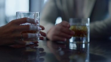 Meslektaşlar yakın planda viski kokteyli içerler. Bilinmeyen iş ortakları lüks bir yerdeki kurumsal etkinlikte alkollü burbon içeceklerini tartışıyor. Toplantıda zengin girişimciler.