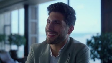 Lüks restoranda viski içen gülümseyen bir adamın portresi. Deniz manzarasında içki içen yakışıklı bir beyefendi. İş sahibi yüzü içkinin keyfini çıkarır. Başarılı bir girişimci biriyle konuşur.