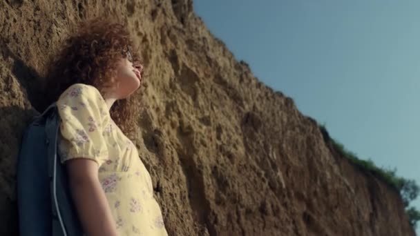 Zrelaksowana Kręcona Dziewczyna Spoglądająca Dół Kamerę Stojącą Blisko Wzgórza Piaskowego — Wideo stockowe