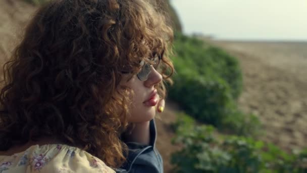 Upset Curly Woman Sitting Sand Shore Alone Sunglasses Close Gorgeous — Stockvideo