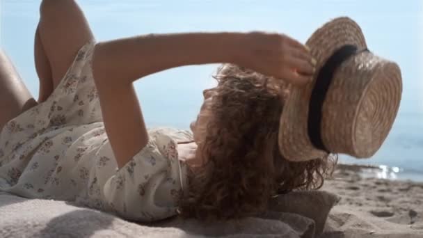 Kumsalda Uzanmış Yüzü Hasır Şapkayla Kaplı Mutlu Bir Kız Kaygısız — Stok video