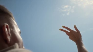 Cheerful pair enjoy sunlight relaxing on beach close up. Unknown young couple lying seacoast summer day. Carefree woman raising hand to blue cloudless sky. Happiness tranquility on nature concept.