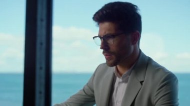 Odaklanmış adam deniz manzarası penceresinde gazete okuyor. Avukat ofiste anlaşma sözleşmesi okuyor. Yakışıklı bir iş adamı şirket raporlarını kontrol ediyor. Güvenilir yatırımcı müşteri kavramı 