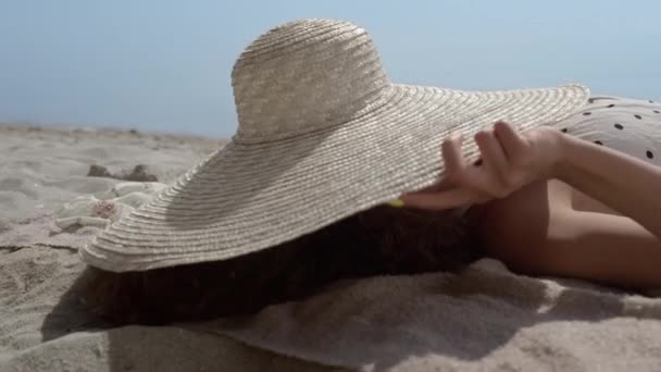 Веселая Улыбающаяся Девушка Глядя Полых Шляп Лежащих Песчаный Пляж Близко — стоковое видео