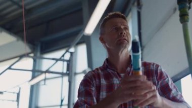 Çiftlik işçisi otomatik robotik fabrikanın sağma sistemini yıkıyor. Modern ahırda hortum kullanarak otomat üreten tarım uzmanı temiz süt ürünleri uzmanı. Akıllı teknolojik tarım kavramı.