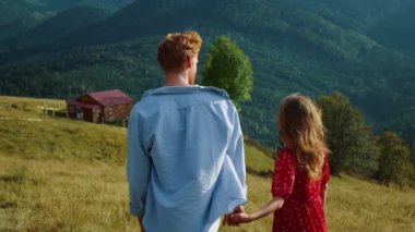 Güzel milenyumlar dağ yürüyüşünde el ele tutuşur. Genç çift Yeşil Tepe 'de yaz tatilinin tadını çıkarıyor. Mutlu aşıklar dışarıda eğlenir. Evli aile balayını kutluyor. Doğa yolculuğu konsepti.