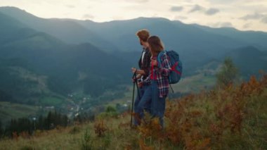 Sportif çift dağlarda doğa yürüyüşü yapıyor. Aktif aile gezisi Green Hill 'de. Genç turistler birlikte resim gibi görünüyor. Sırt çantaları yürüyüş parkuruna gidiyor. Turizm konsepti.