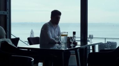 Çekici bir adam lüks bir restoranda hafta sonu yemeği yiyor. Otel salonunun barında klasik yemek masası servisi yapan zarif bir garson. Zengin ziyaretçiler panoramik kafede dinleniyor. Zengin yaşam tarzı konsepti.