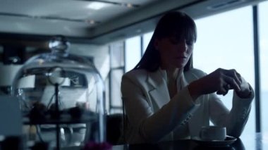 Depressed woman thinking at cafe closeup. Stressed businesswoman portrait having coffee cup alone at panoramic windows view bar. Melancholic leader person in dark interior. Emotional breakdown concept
