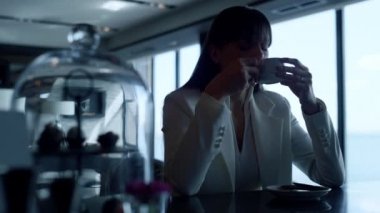 Upset woman sipping espresso closeup. Depressed executive taking coffee cup break at panoramic windows cafe. Stressed manager think family financial problems rest with beverage. Person crisis concept