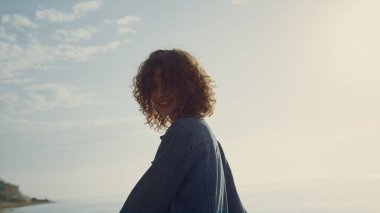 Sahilde kameraya poz veren oyuncu kız. Kumsalda gülümseyen bir kadın. Kadın model el kaldırıyor. Özgürlüğü hisseden mutlu kadın. Şık elbiseli hippi kız. Moda konsepti