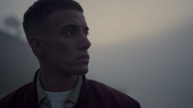 Deniz sahilinde yürüyen ciddi bir adam. Sahilde duran, hayal kırıklığına uğramış bir portre. Yakın çekim erkek hippi sisli okyanus manzarası. Delikanlının morali bozuk. Güneşin doğuşundaki gizemli sahne