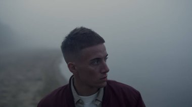 Sabah sisinde okyanus ufkuna bakan depresif bir adamın portresi. Yakından deniz kıyısında yürüyen ciddi bir adam. Dışarıdaki kameraya poz veren bir erkek model. Sıradan bir adam üzgün hissediyor. Yalnızlık sonbahar sahnesi