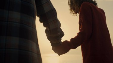 Gün doğumunda sahilde el ele tutuşan mutlu çift. Okyanusta balayının tadını çıkaran genç ve güzel bir evlilik. Sevgi dolu, oyuncu görünüşlü bir adam. Güneş denizin üzerinde parlıyor. İlişki kavramı 