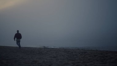 Sisli bir sabahta deniz manzarası seyreden düşünceli bir adam. Arkaya bakan yalnız adam kumlu sahilde yürüyor. Erkek hippi gün doğumunda okyanus manzarasının tadını çıkarıyor. Depresyonda olan genç bir adam. Hayal kırıklığı konsepti