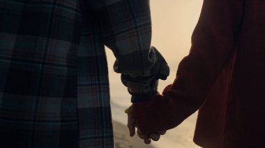 Gün batımında okyanus sahilinde yürüyen tanınmayan bir çift. Yakından kadın ve erkek el ele tutuşuyor. Deniz kıyısında çıkan şık sevgili ve sevgili. Akıllı telefon tutan kız. Romantik konsept