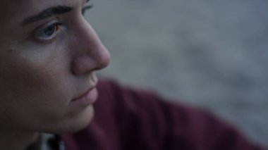 Yakından kumsalda oturan ciddi bir adam. Üzgün yüzlü yakışıklı bir adam. Dışarıya bakan üzgün erkek portresi. Hayatı düşünen barışçıl bir adam. Depresyon ve üzüntü konsepti